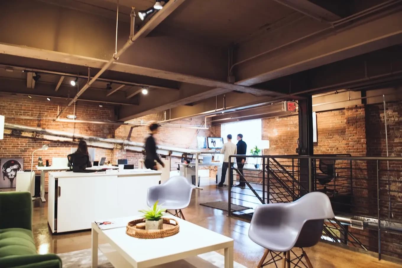 Office workspace with exposed brick, desks and lounge seating
