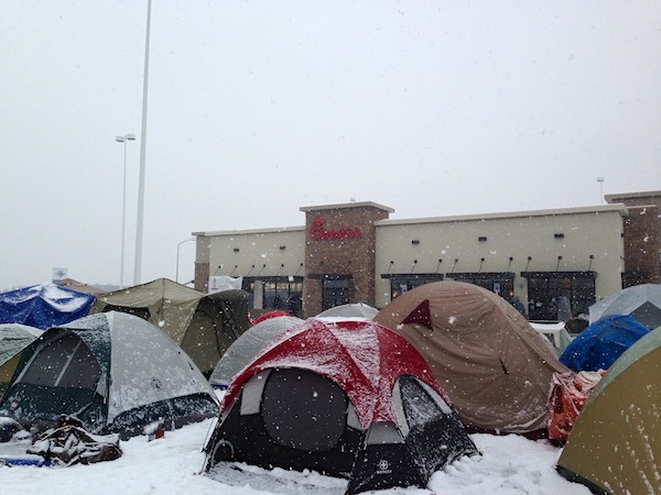 Customers camped in tents in falling snow outside a Chick-fil-A restaurant ahead of its grand opening